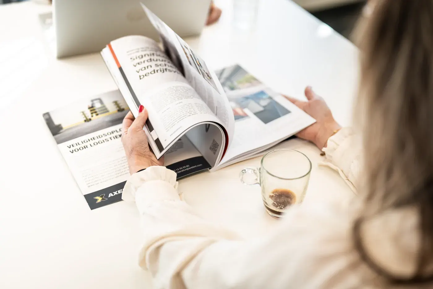 Un lecteur feuillette un magazine professionnel et s'arrête à une page de publicité